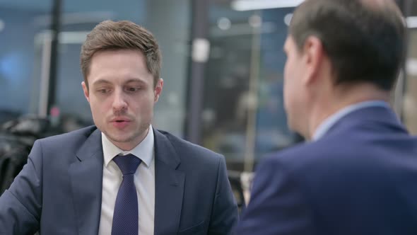 Rear View of Businessman Talking to Colleague