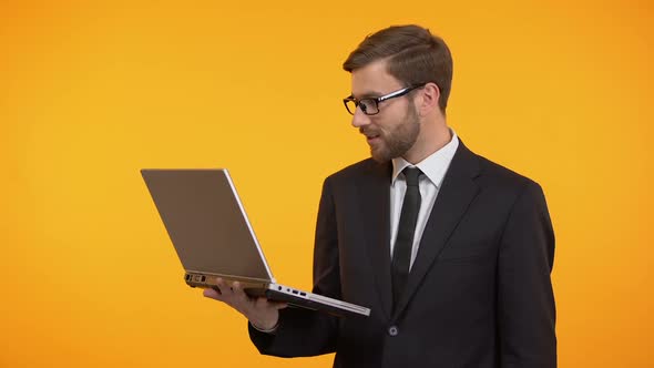 Happy Man Holding Laptop Showing Thumbs Up, Satisfied With New Software Work