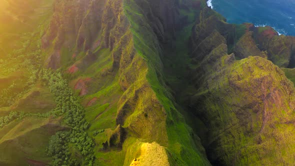 Grassy Rocks of Mountainous Coastal Terrain of Hawaii Illuminated By Sunset Light, Aerial Shot