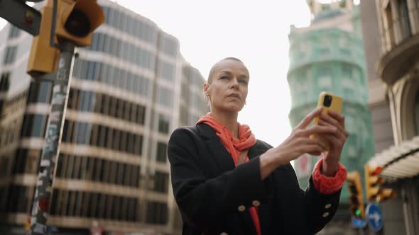 Positive bald woman looking at the map on phone