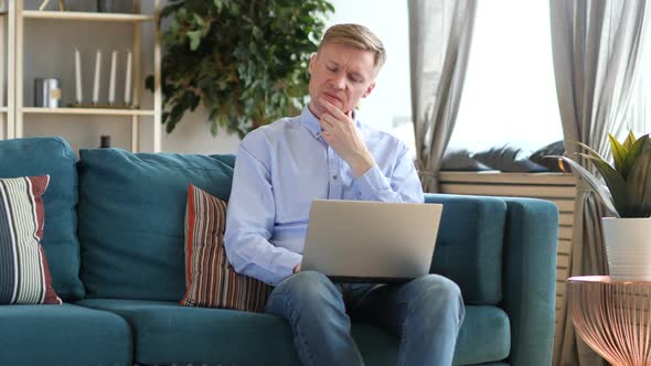 Pensive Middle Aged Man Working on Laptop