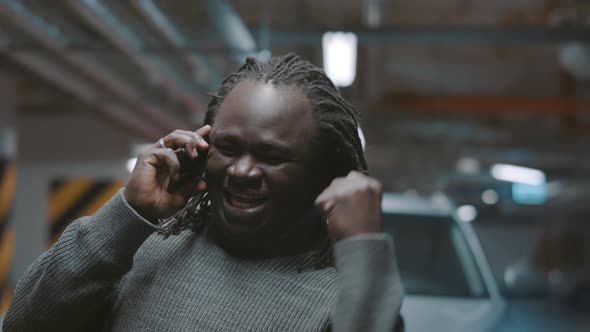 Excited African American Black Man Having Phone Conversation in the Underground Parking