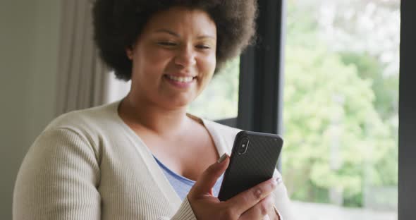 Video of happy plus size african american woman using smartphone