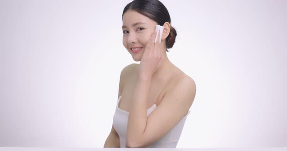 Slow Motion Beauty Portrait Of Young Attractive Asian Woman Cleaning Face With Cotton Pad Gently.