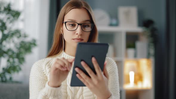 Woman Sitting at Table and Using Digital Tablet