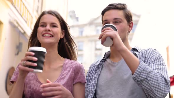 Young People Drinking Coffee And Walking At City Street