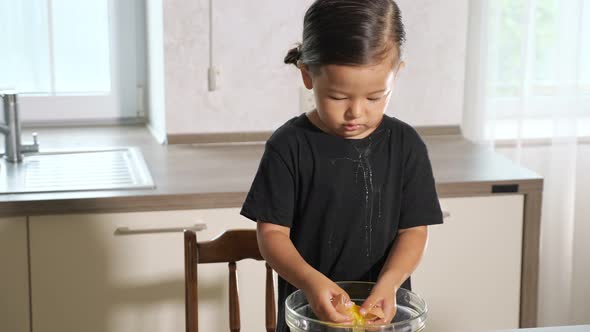 Funny Toddler Squeezes Egg Which Splashes on Black Shirt