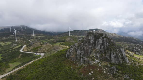 People on Caramulinho viewpoint and wind turbines in rural mountain landscape, Caramulo in Portugal.