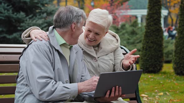 Happy Grandparents Couple Family Resting with Computer in Park Middle Aged Woman Senior Man Hold