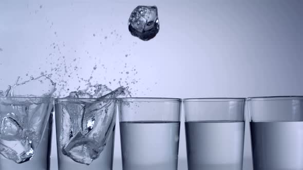 Slo-motion ice cubes falling into glass