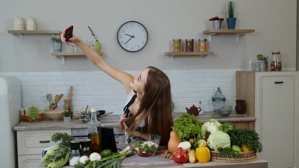 Vegan Blogger Girl Making Photos and Taking Selfies for Social Media on Smartphone at Kitchen