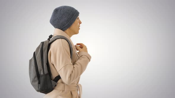 Woman with Backpack in Outdoor Clothes Walking and Coughing on Gradient Background