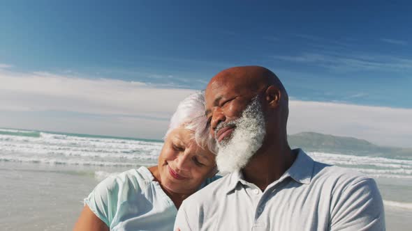 Smiling senior african american couple embracing at the beach