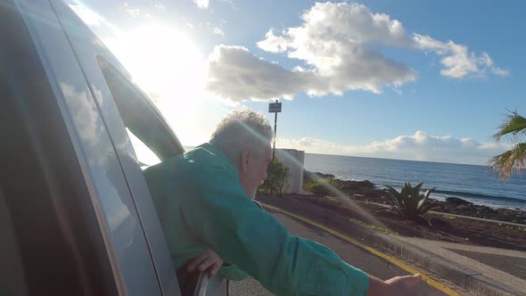 close up of one mature man outside of the window's car looking and enjoying the outdoors