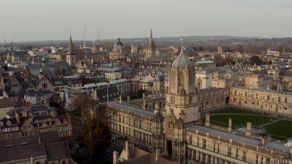 Drone shot past Christ Church Tom Tower towards Bodleian library Radcliffe camera Oxford golden hour