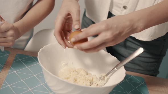 Closeup of Female Hands Breaking Raw Egg for Making Dough