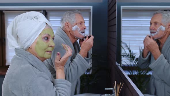 Senior Grandmother Applying Facial Mask and Grandfather Shaving with Manual Razor Blade at Bathroom