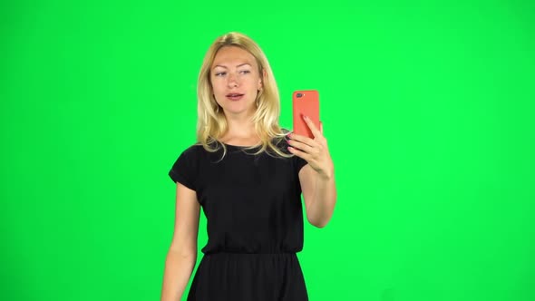 Girl Goes and Takes a Selfie, Then Looks Through the Photos on the Smartphone. Chroma Key. Slow