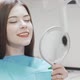 Beautiful Woman Examining Her Teeth in the Mirror at the Dental Clinic - VideoHive Item for Sale