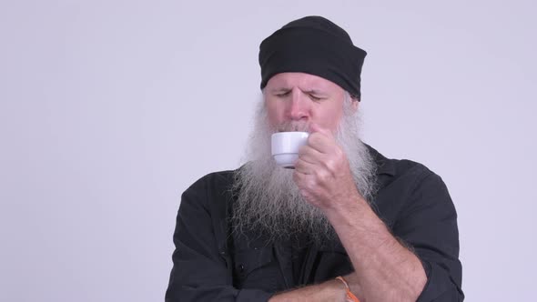 Face of Mature Bearded Hipster Man Relaxing While Drinking Coffee