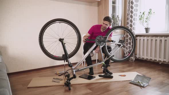 Man Turns the Pedals Bicycle Listens to Sound Wheel Squeaks When Spinning