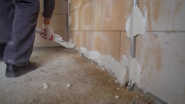 The Process of Applying Plaster From a Hose to the Wall