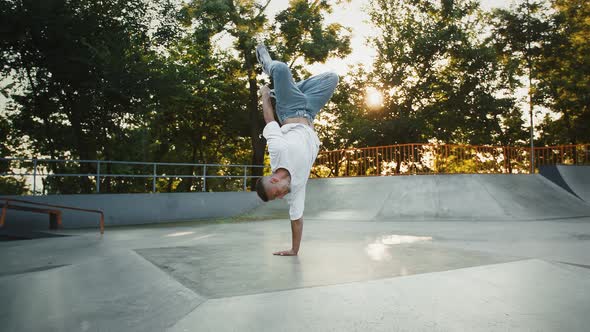 Young Fellow is Performing Breakdance Standing on His Hand Upside Down Jumping and Spinning on Pump