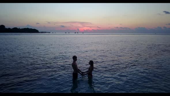 Man and woman relax on luxury coast beach lifestyle by blue lagoon and white sand background of the 