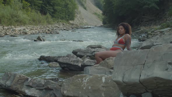 Pretty African American Woman in Swimsuit Enjoying Recreation and Freedom at Mountain River