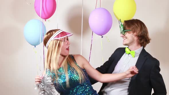 Cheerful woman and man dancing in photo booth