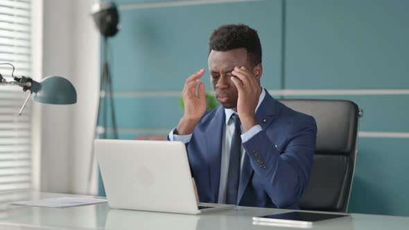 African Businessman Having Headache While Working on Laptop