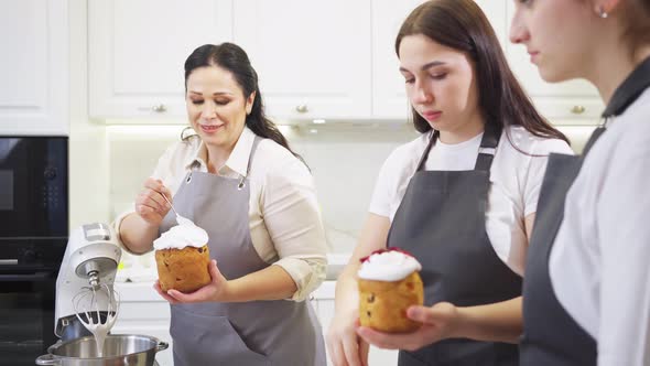 a Mother and Daughters Decorate Icing Dried Berries and Flowers Easter Cakes