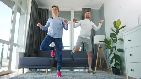 Caucasian Couple is Doing Cardio Exercise at Home in Cozy Bright Room Slow Motion