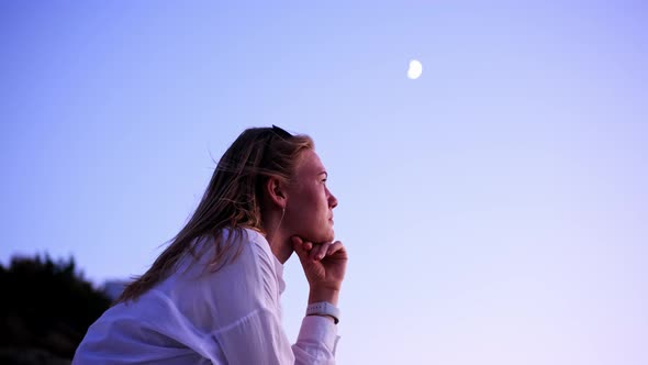 Nice Attractive Blonde Young Woman at Sunset on Background of Moon in White Shirt and Black Top