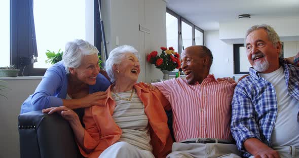 Happy senior friends having fun while relaxing on sofa 4k