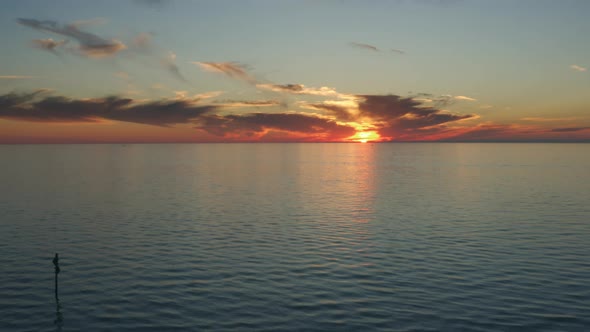 Slow aerial descent of the sun setting on Gulf at Clearwater