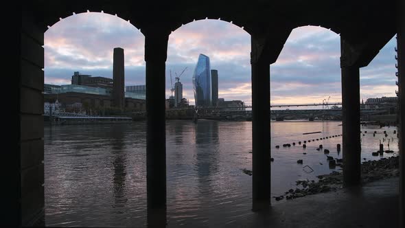 Tate Modern and London city skyline at sunset on the River Thames beach at low tide by Millennium Br