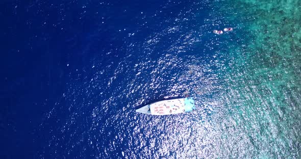 Luxury fly over clean view of a white paradise beach and blue sea background in high resolution 4K