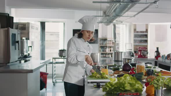 Portrait of Female Cook Cutting Green Celery in Gourmet Kitchen