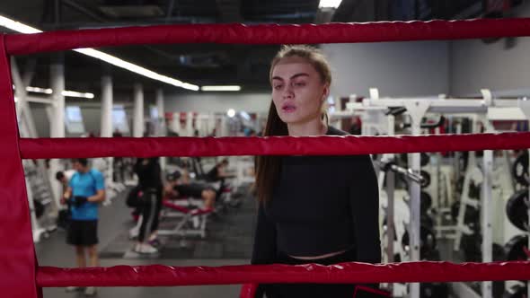 Young Woman Walks To a Boxing Ring in the Gym