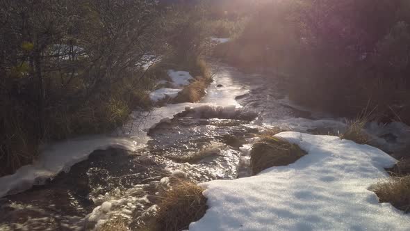 TILT UP Sun beams lighting a brook on mountain landscape