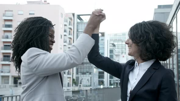Two Successful Businesswomen Shaking Hands on Street
