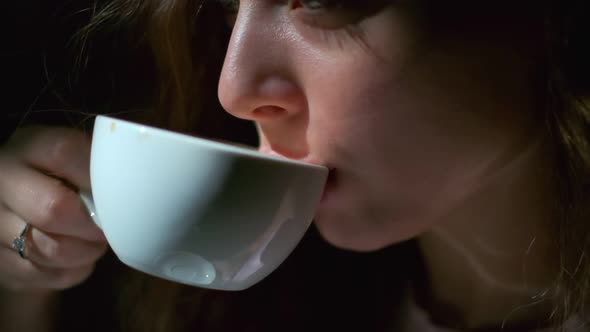 Closeup of Girl Drinking Coffee with Pleasure From a White Cup