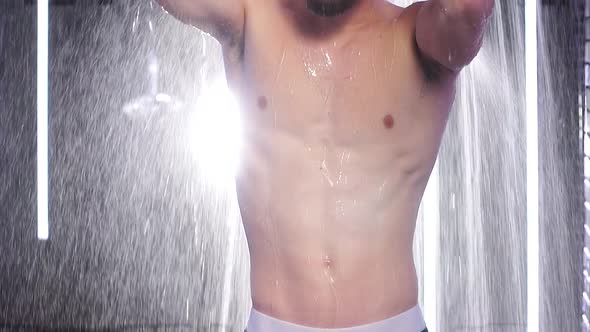Caucasian Young Attractive Man with Muscular Body Standing Under Running Water in Shower Room