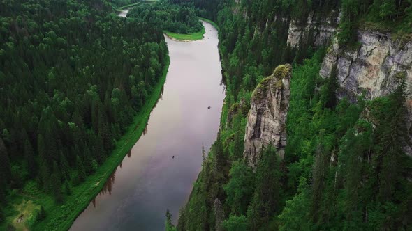 Landscape of Rocky Pillar Standing By Calm River with Upright Cliff Surrounded with Horizonless