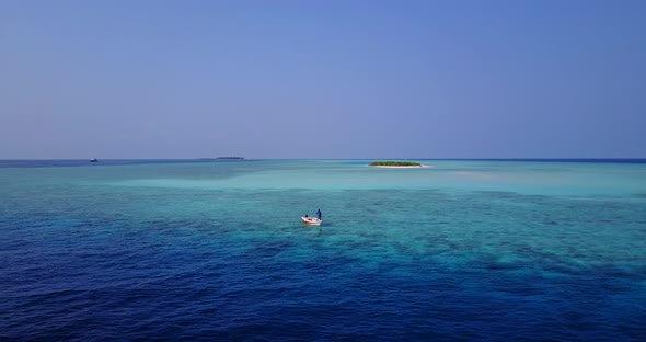 Daytime fly over abstract shot of a sunshine white sandy paradise beach and blue ocean background in