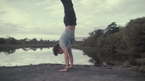 Athletic man performs handstand strength exercise breathtaking view