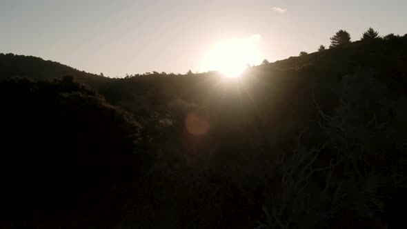 Panning aerial shot with Sun Flare over mountain. Silhouette