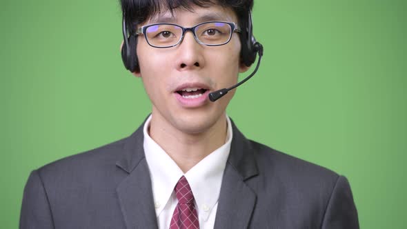 Young Asian Businessman Smiling and Working As Call Center Representative