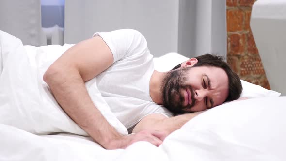 Uncomfortable Man Sleeping on Side in Bed at Night Restlessness